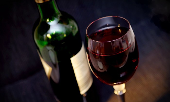 glass of red wine with bottle